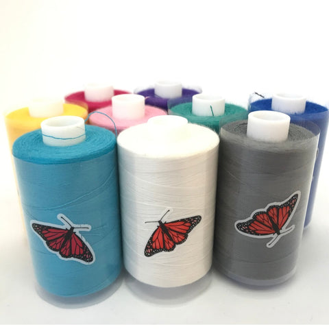 Spools of Butterfly brand spun polyester sewing thread in various colors, with a butterfly design on the white spool in the foreground.