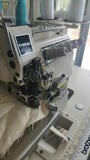 A detailed close-up of the needle area and presser foot of a Typical brand industrial sewing machine processing a light-colored textile.